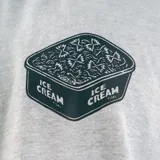 Remera gris de manga corta con cuello redondo y estampado pequeño en el pecho.