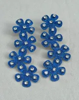Par de aros colgantes con forma de flores azules con glitter y strass.