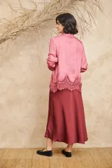 Camisa de seda color rosado con cuello clásico, abotonada al frente, mangas largas con puños abotonados y terminación inferior con encaje floral.