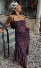 Conjunto de top y falda midi color borgoña con estampado de lunares blancos. El top es de tirantes finos y la falda tiene volantes en el ruedo.