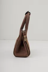 Cartera pequeña de cuero marrón oscuro, con asas superiores y cierre de cremallera lateral visible. Presenta el logo de la marca grabado en el frente.