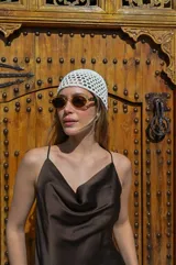 Lentes de sol ovalados con armazón color verde translúcido y lentes marrones.