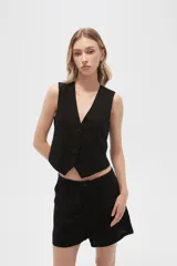 Chaleco negro sin mangas con cuello en V y cierre frontal con botones.