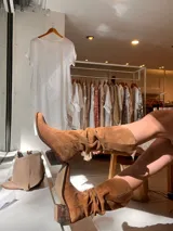 Botas de cuero color marrón, de caña alta y estilo cowboy.