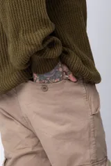 Pantalón cargo color beige con bolsillos laterales con solapa y botón. Corte ajustado.