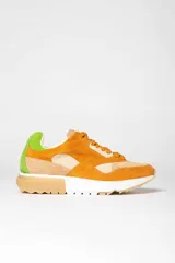 Zapatillas deportivas color mostaza con detalles en beige, verde y blanco.