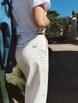 Pantalón blanco de gabardina con pespuntes en marrón chocolate, corte recto y tiro alto.