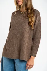 Sweater color beige de tejido texturado, con cuello redondo y mangas largas.