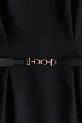Vestido negro a la rodilla con escote bote y pliegues de caja invertidos adelante y atrás. Modelo de manga corta con cintura entallada, cinturón extraíble con hebilla de metal y bajo recto. Cierre oculto en la espalda. Sin forrar.