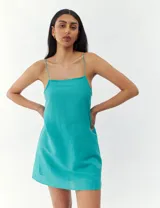 Vestido corto color crema con breteles finos y corte recto.