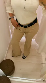 Pantalón de vestir color beige, de tiro alto, corte recto y terminación acampanada.