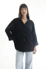 Camisa de pana color borgoña, de corte oversize, con cuello clásico, cierre frontal con botones, dos bolsillos con solapa en el pecho y mangas largas con puños abotonados.