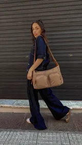 Bandolera de tafeta impermeable, liviana, con dos compartimientos principales, dos bolsillos con cierre y correa regulable con hebilla.