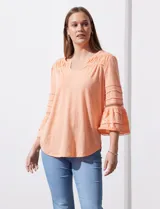 Blusa color celeste con escote en V, mangas largas acampanadas con detalle de crochet y frunces en los hombros.