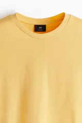 Remera amarilla de algodón liviano, corte estándar, con cuello redondo ribeteado y bajo recto.