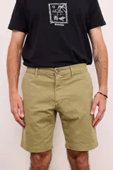 Bermuda de gabardina color verde oliva, con bolsillos laterales y traseros. Cierre frontal con botón y cremallera.