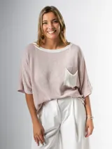 Remera tejida en hilo italiano, color beige, con cuello a la base y bolsillo frontal. De caída relajada y silueta amplia.