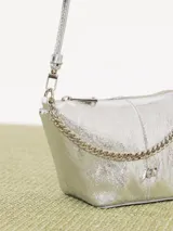 Bandolera negra de cuero vacuno con correa regulable y cadena metálica ornamental. Interior forrado en cuero vacuno con bolsillo interno con cierre.