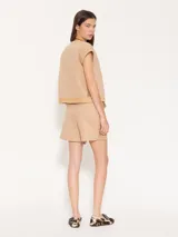 Short color beige de lino y algodón, con bordado tipo crochet en los laterales y cordón tubular para anudar en la cintura.