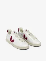 Zapatilla deportiva de diseño clásico en color blanco con detalles en rojo y logo distintivo.
