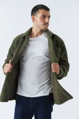 Sobrecamisa color crema de poliéster con textura de sherpa, cuello camisero, cierre con botones marrones, bolsillo de parche en el pecho y logo en etiqueta de cuero. Corte recto.