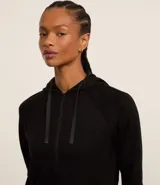 Campera deportiva verde esmeralda de modal, con capucha ajustable con cordón, cierre frontal con cremallera y bolsillos laterales.