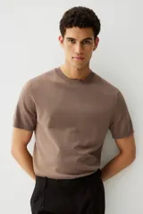 Remera marrón de punto fino, con cuello redondo y mangas cortas.