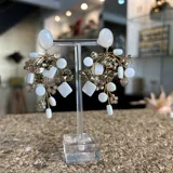 Aros colgantes hechos a mano con cristales dorados y nácar blanco. Se ajustan con perforación.