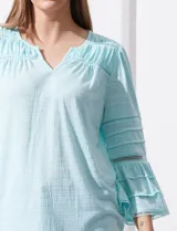 Blusa color celeste con escote en V, mangas largas acampanadas con detalle de crochet.