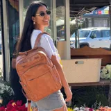 Mochila marrón de eco-cuero, con compartimento para notebook de hasta 15,9″, múltiples bolsillos y banda trasera para trolley.