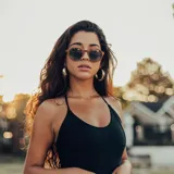 Lentes de sol con montura redonda de madera y lentes degradadas de gris a transparente.