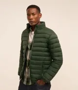 Campera puffer ultraligera color beige, con cuello alto, cierre por cremallera y bolsillos con cremallera. Incluye bolso de almacenamiento.