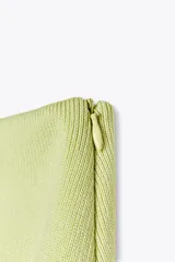 Falda midi color crudo, de tiro alto con cintura elástica y detalle de tejido combinado plisado y semitransparente. Cierre lateral con cremallera oculta en costura.