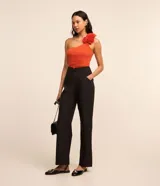 Pantalón de vestir negro de corte recto, con bolsillos laterales y cierre de cremallera lateral. Presenta detalles de hilo metalizado en la trama.