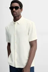 Camisa celeste de corte recto, manga corta y cuello solapa.