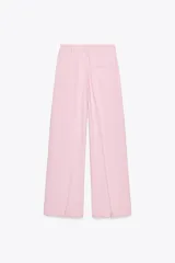Pantalón ancho color rosa claro, de tiro alto con pinzas delanteras, bolsillos frontales y cierre frontal con cremallera y botones.