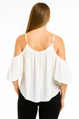 Blusa blanca con breteles finos y hombros descubiertos, corte holgado y escote redondo.