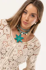 Saco color crudo de crochet con botones y mangas largas.