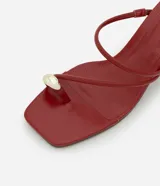 Sandalias mule rojas de material sintético con punta cuadrada, tiras finas, detalle de dedera con adorno dorado y tacón bloque mediano.