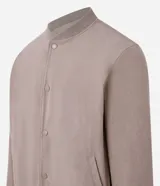 Campera bomber marrón de terciopelo pana con cuello redondo, cierre con botones a presión, bolsillos laterales, puños y cintura elastizados.