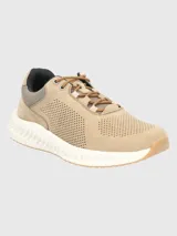 Zapatilla acordonada de cuero color beige con perforaciones en los laterales y suela blanca con base de goma color caramelo.