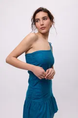 Vestido largo rojo de algodón y lino, con un hombro descubierto, bretel fino con lazo, recorte en la cintura y falda asimétrica con volados.