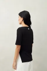 Remera negra de manga corta, con cuello recto y terminación en pico.