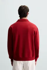 Sudadera color crema de corte recto, con cuello polo y cierre de cremallera metálica.