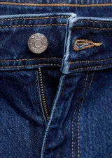 Pantalón de jean azul oscuro, de corte culotte, tiro alto y bajo deshilachado. Con cierre de cremallera y botón, trabillas y bolsillos traseros. Tejido elástico de algodón estilo tejano vaquero.