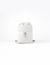 Mochila tipo saco color natural, confeccionada en PVC y algodón, con cordón ajustable.