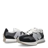 Championes New Balance modelo 327, con capellada en tonos negro, gris oscuro y gris claro. Presenta el logo 'N' sobredimensionado en gris claro y cordones blancos. La suela es gruesa, de color blanco con detalles en goma gris/tostada en la punta y el talón.