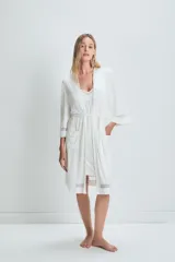 Bata blanca de viscosa y elastano con mangas 3/4 y detalle de puntilla en los puños y el ruedo. Incluye cinturón para ajustar en la cintura.