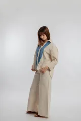 Camisa color beige con solapas y cierre con botones.