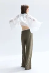 Pantalón sastrero color verde oliva en tejido liviano de mezcla de lino y viscosa con pinzas adelante y atrás. Modelo de tiro alto con cierre, botón nacarado y piernas amplias.